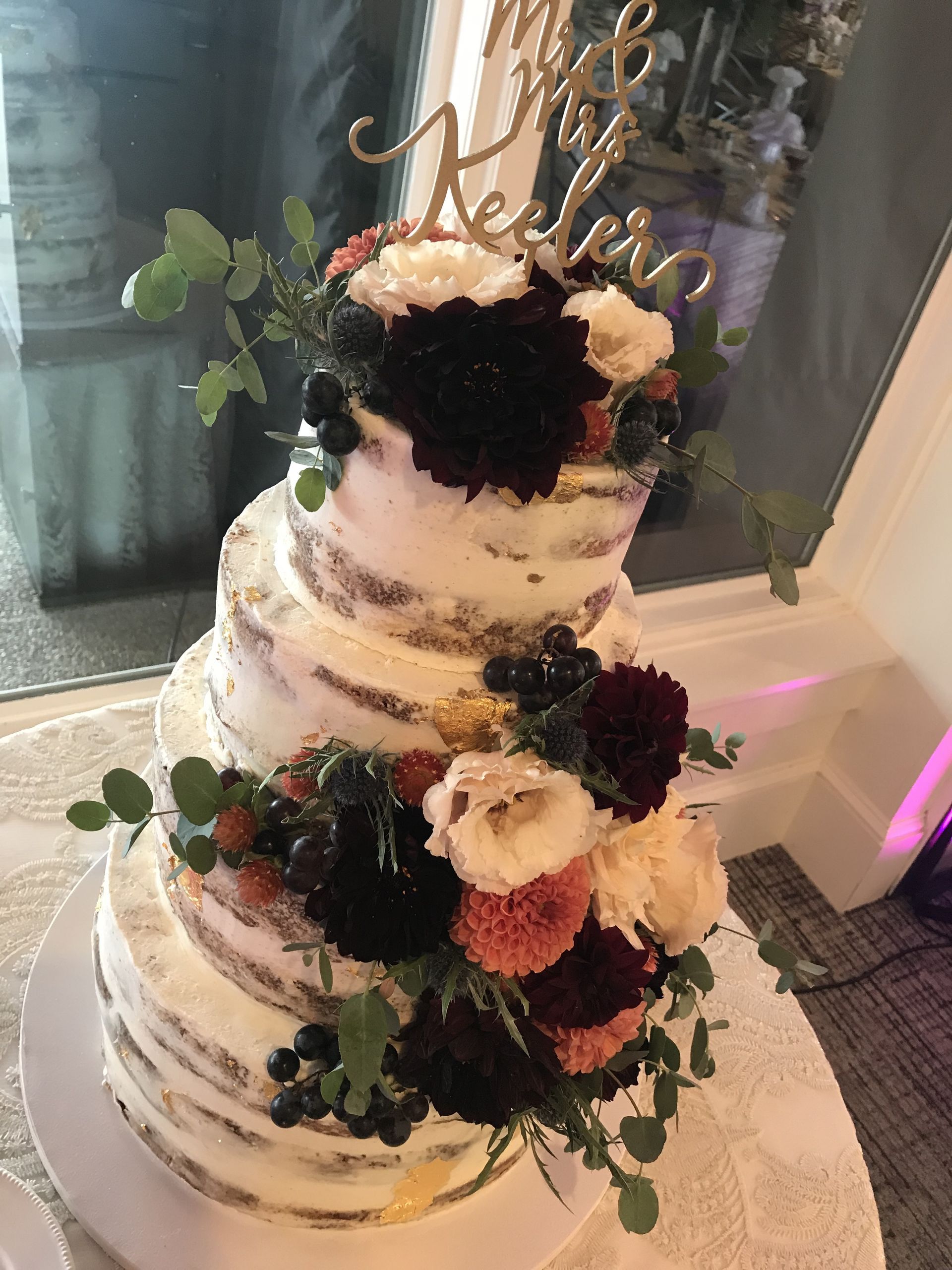a wedding cake with flowers on top of it is sitting on a table .