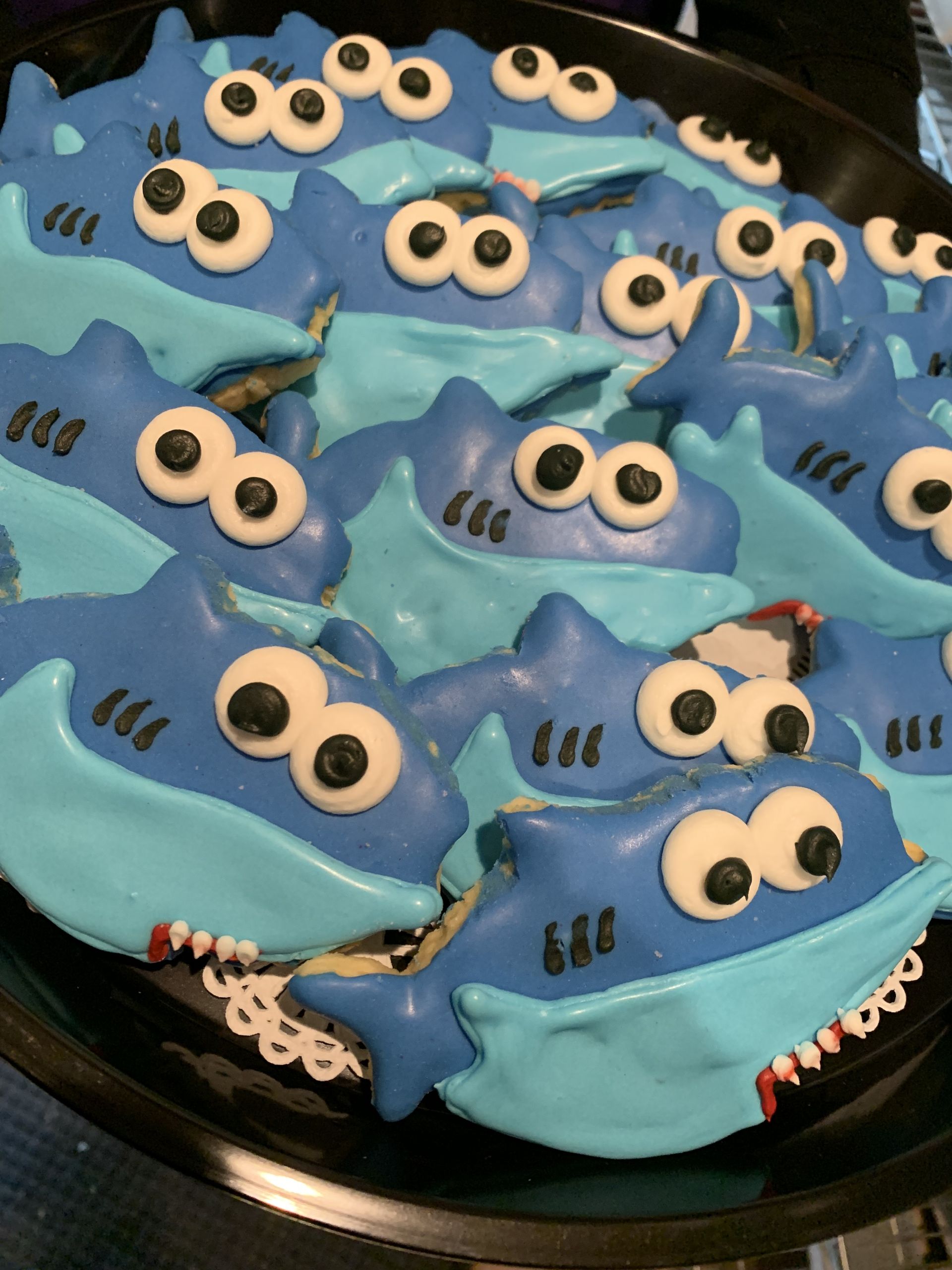 a black plate topped with cookies that look like sharks
