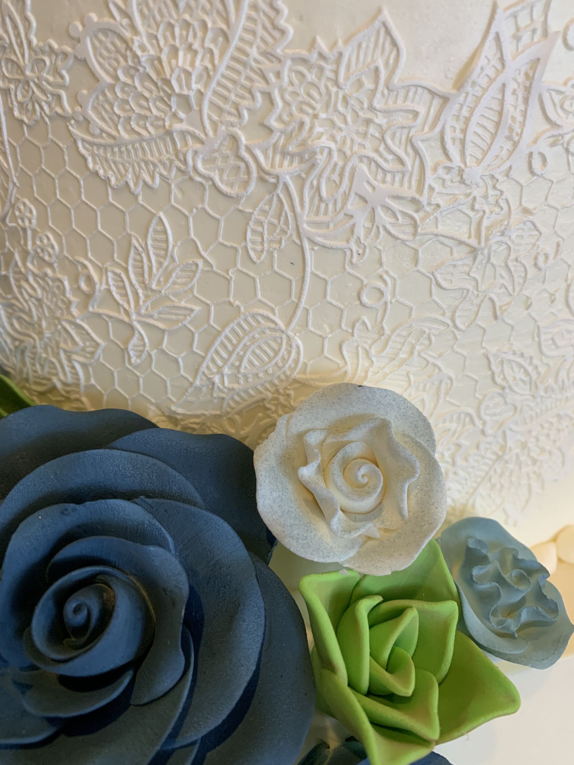 a white cake with blue and green flowers on it