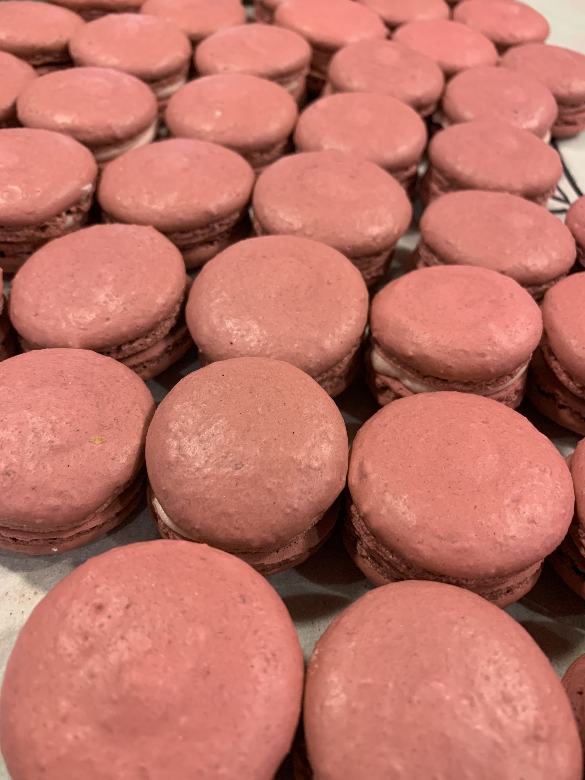 a bunch of pink macarons are sitting on a table
