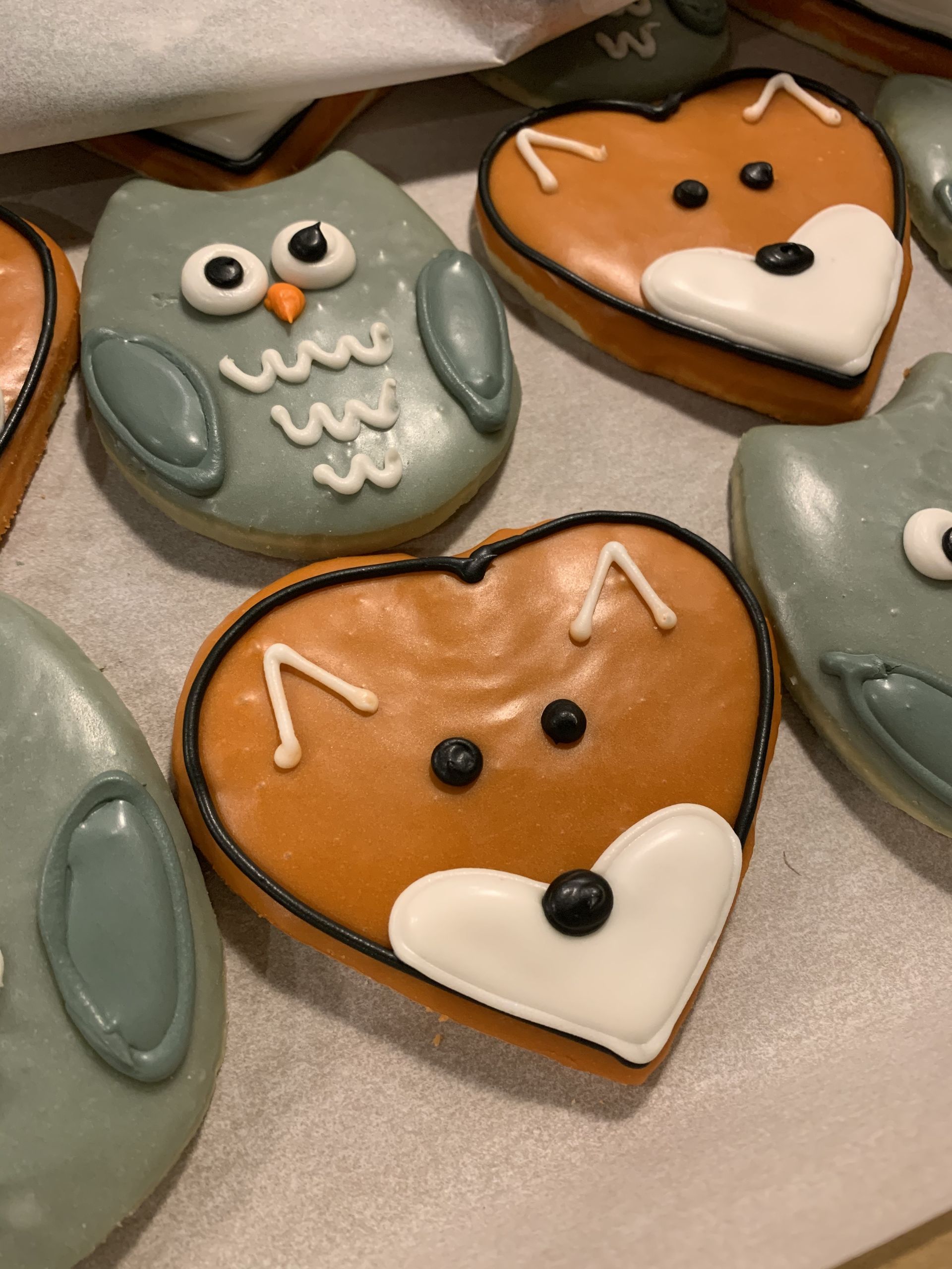 a heart shaped cookie with an owl and a fox on it