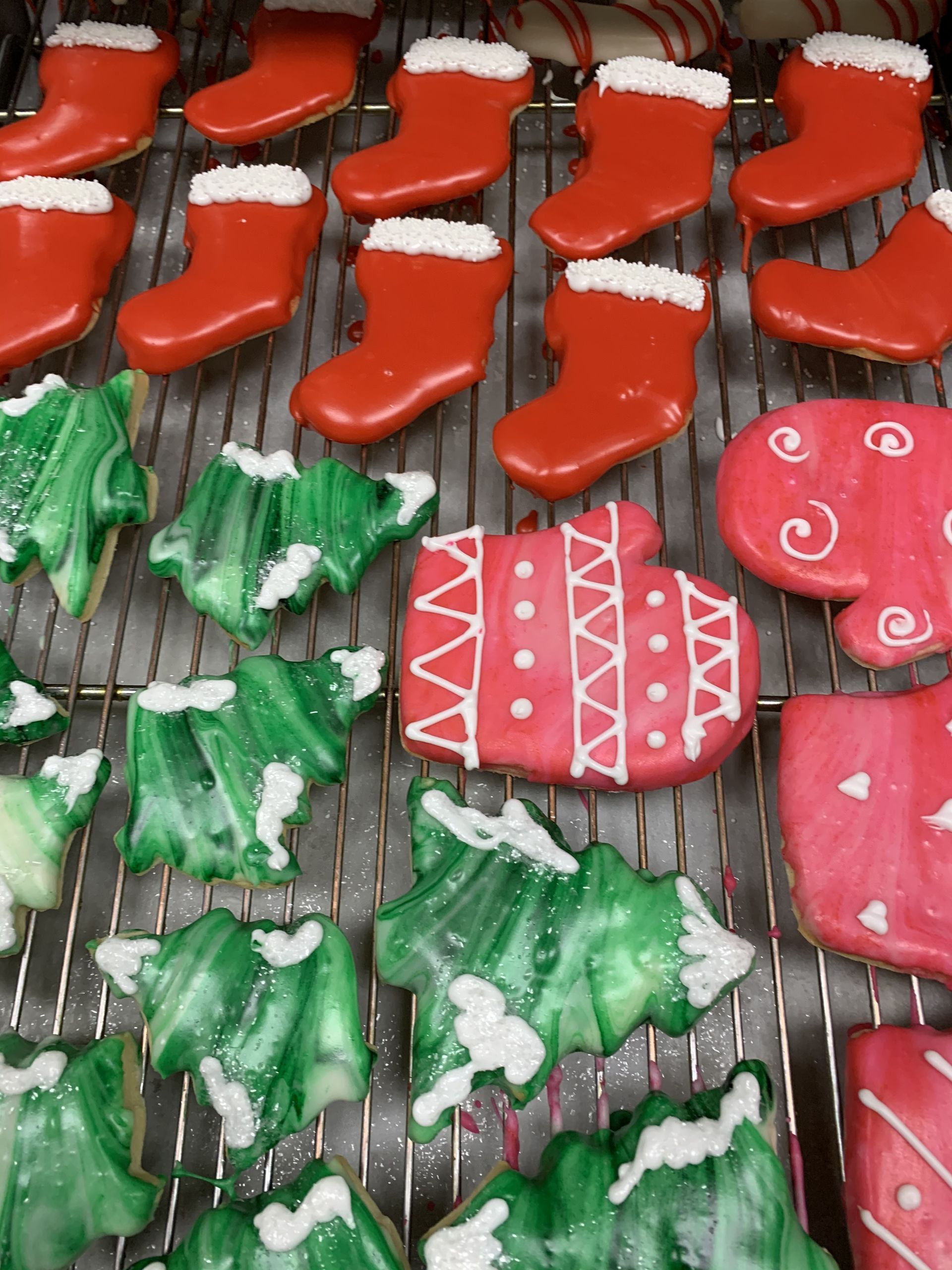 a bunch of christmas cookies are sitting on a cooling rack