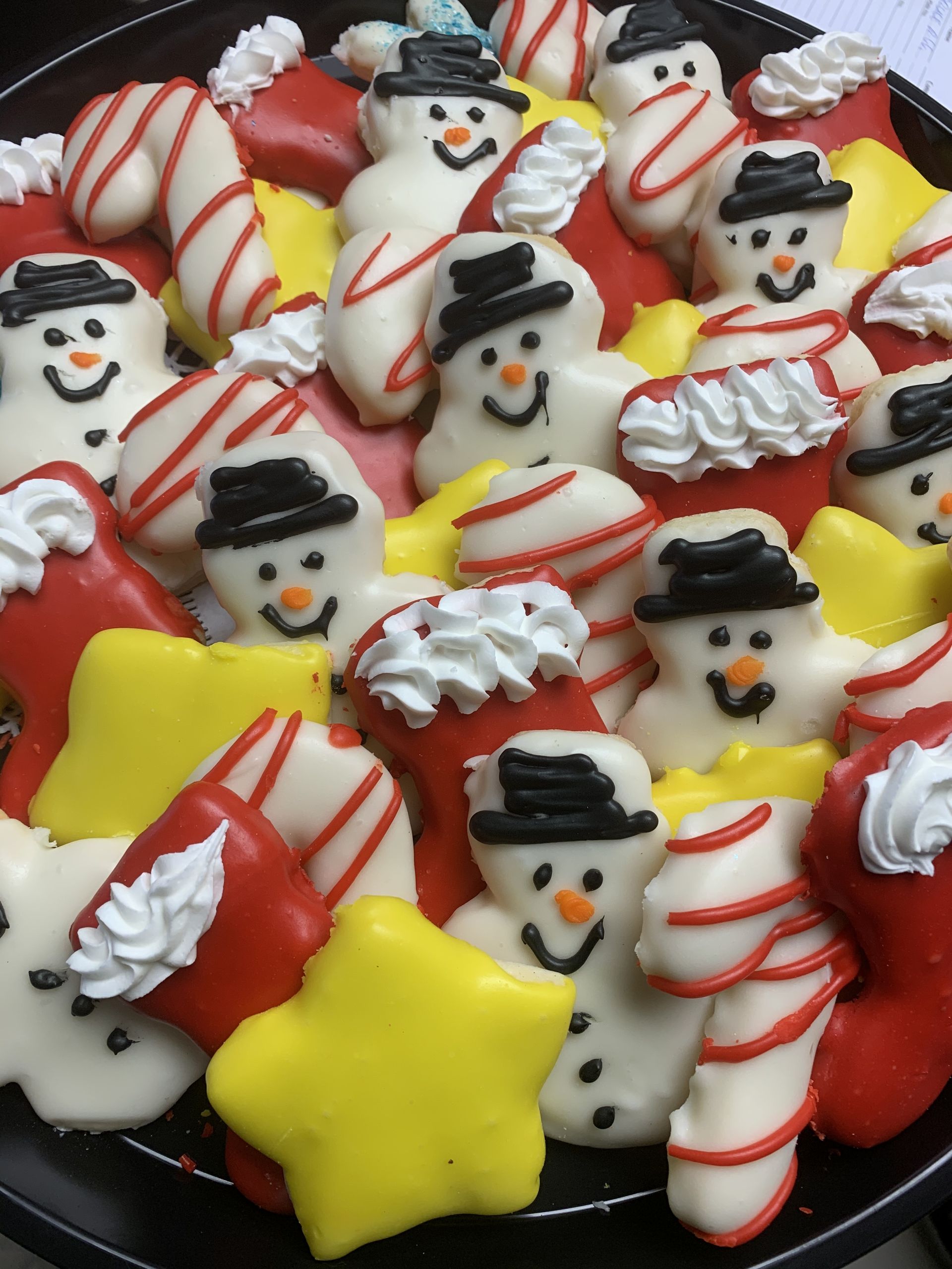 a tray of christmas cookies with snowmen stars and candy canes