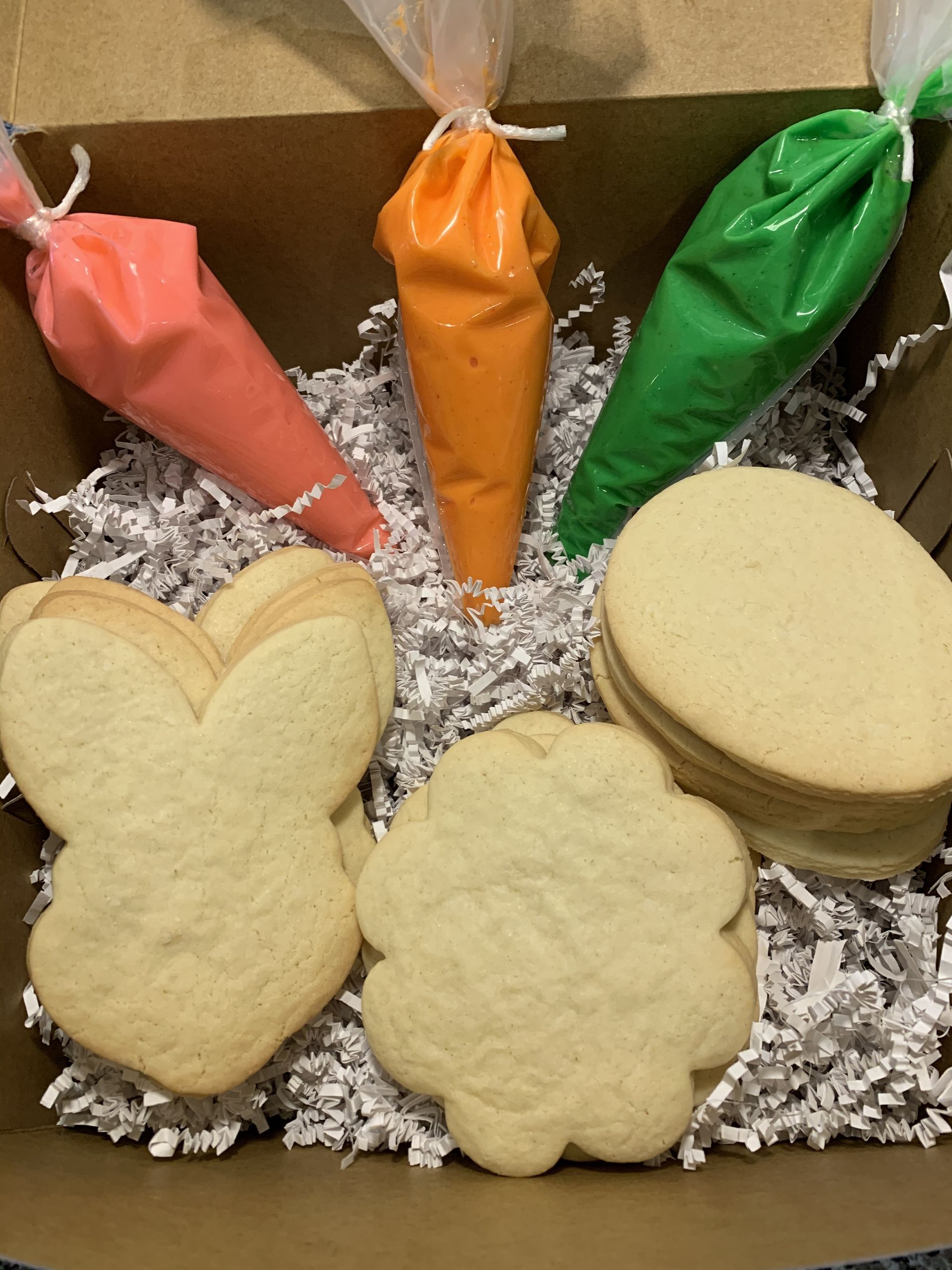 a box filled with cookies and frosting bags .