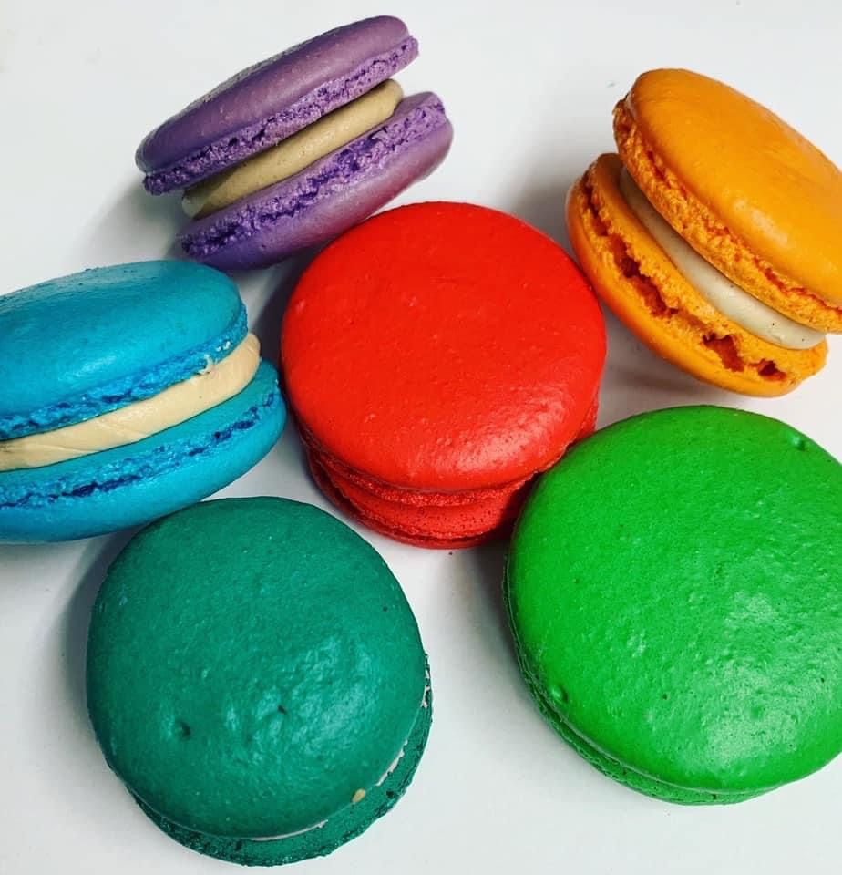 a bunch of different colored macarons on a white surface
