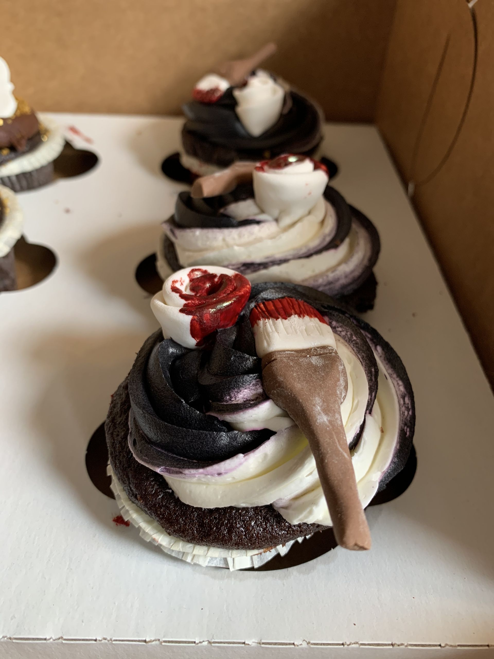 a box of chocolate cupcakes with a spoon on top