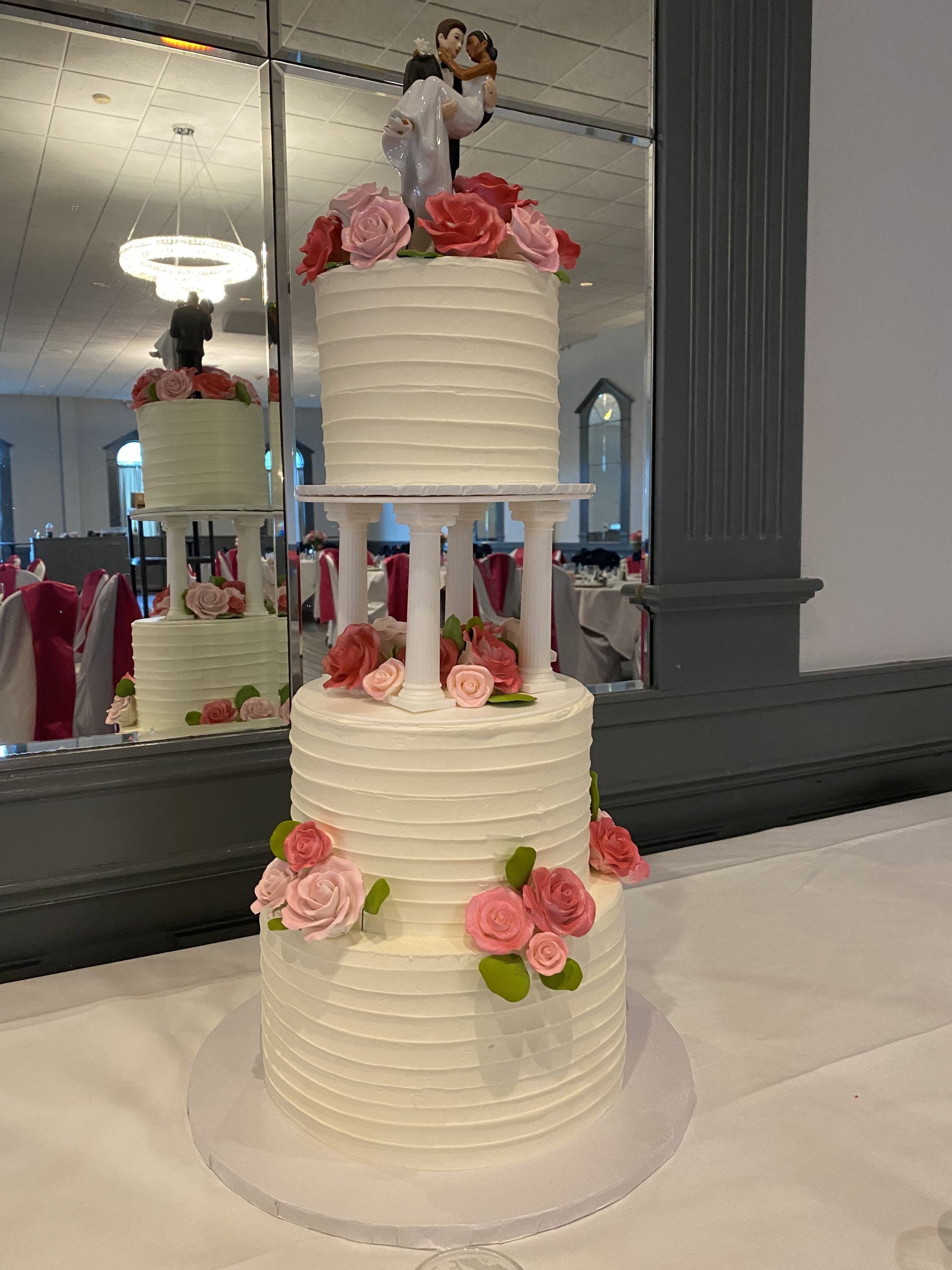 a wedding cake with a bride and groom figurine on top is sitting on a table .