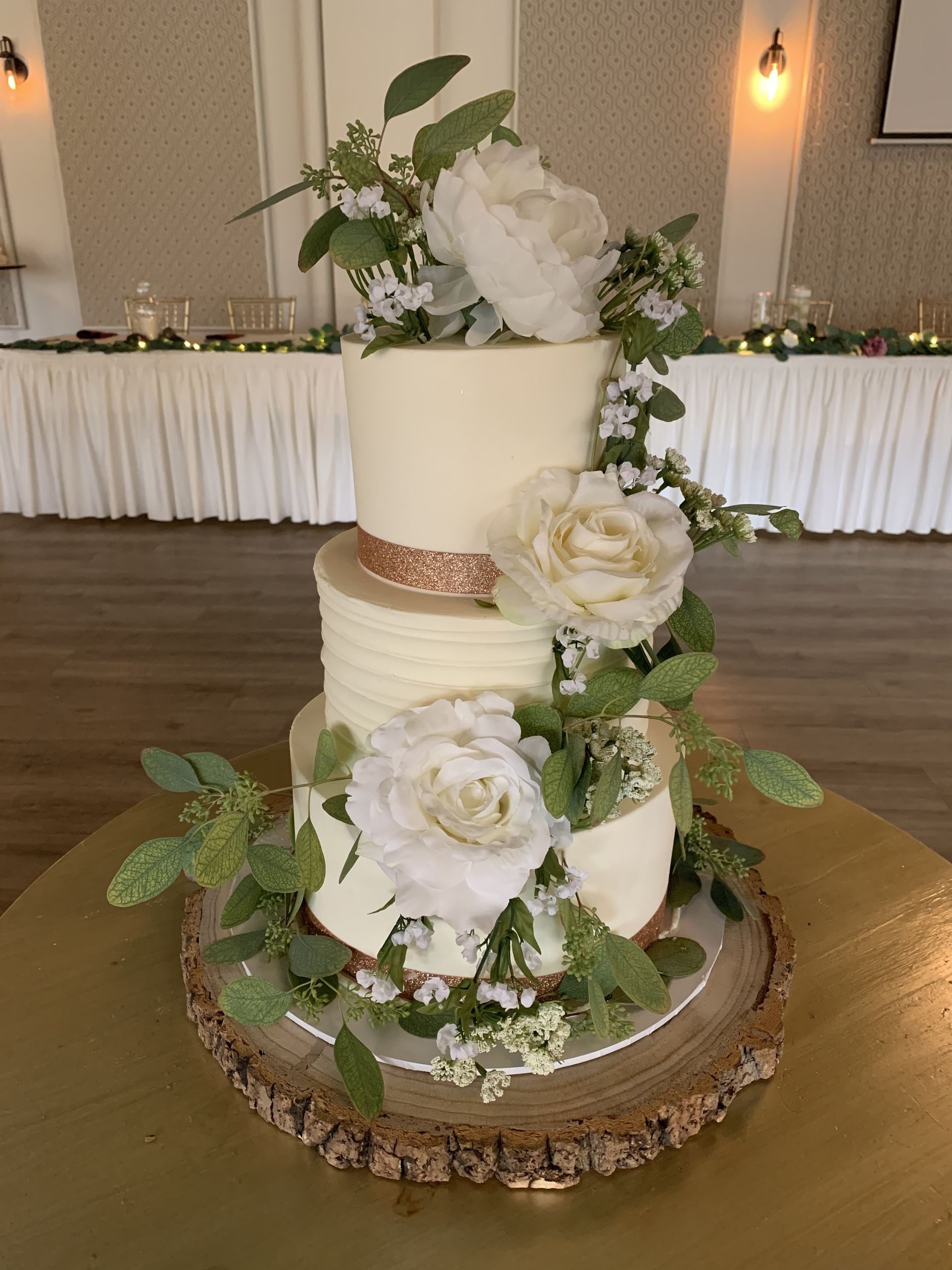 a wedding cake is sitting on top of a wooden table .