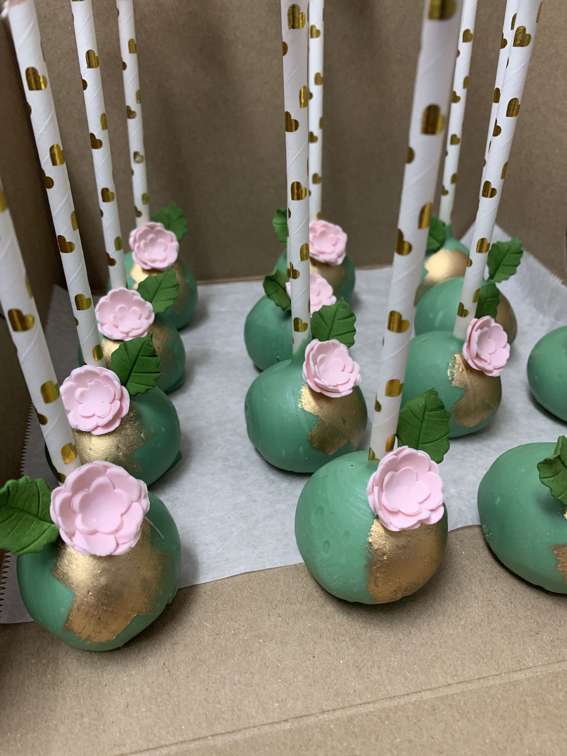 a bunch of cake pops with pink flowers on them