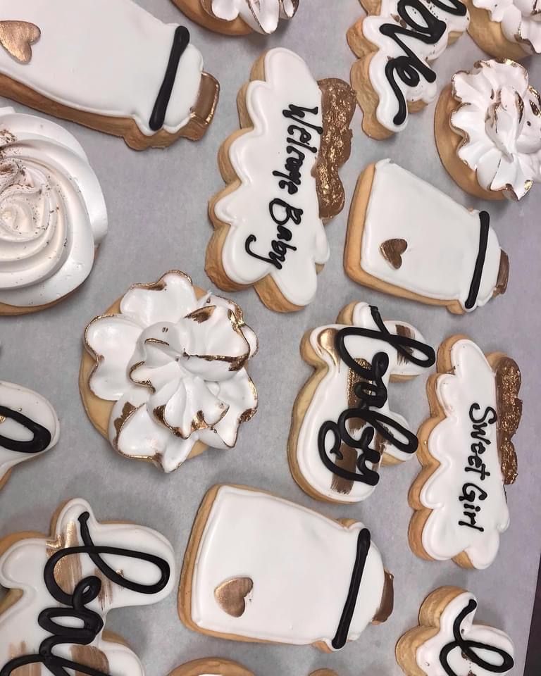 a bunch of cookies with one that says welcome baby