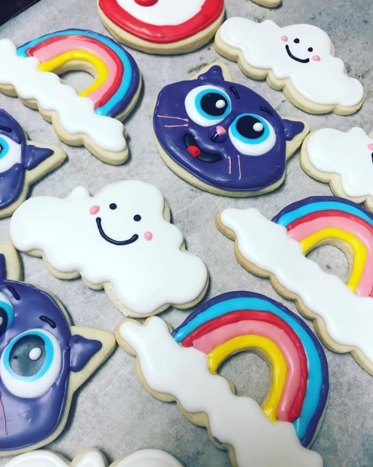 a bunch of cookies with rainbows and clouds on them
