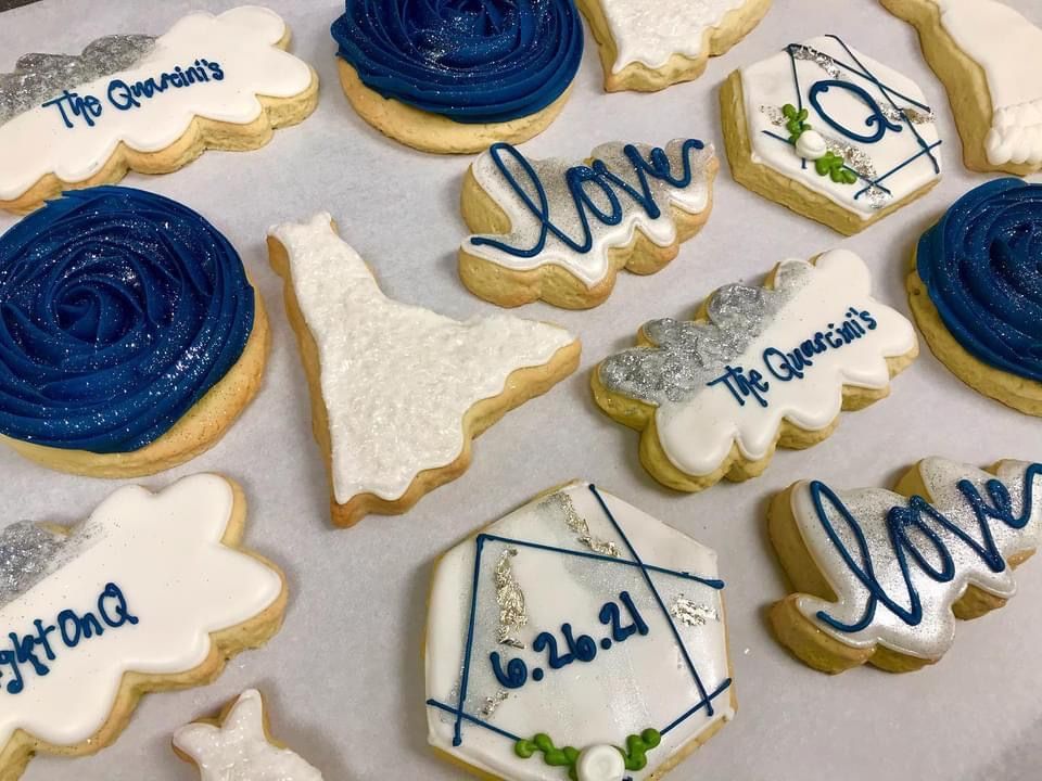 a bunch of cookies with blue frosting and the word love on them