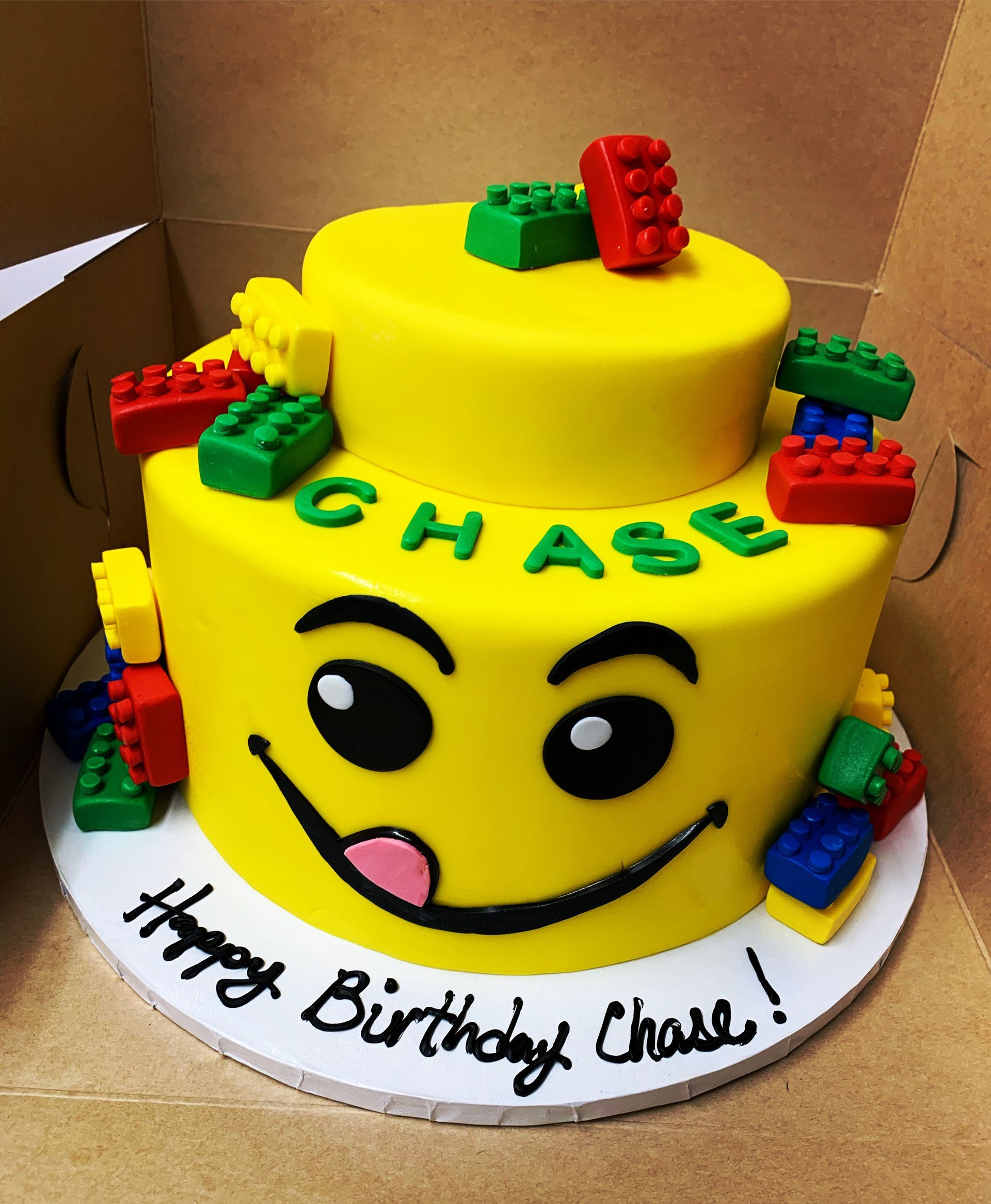 a birthday cake for chase with a lego face on it