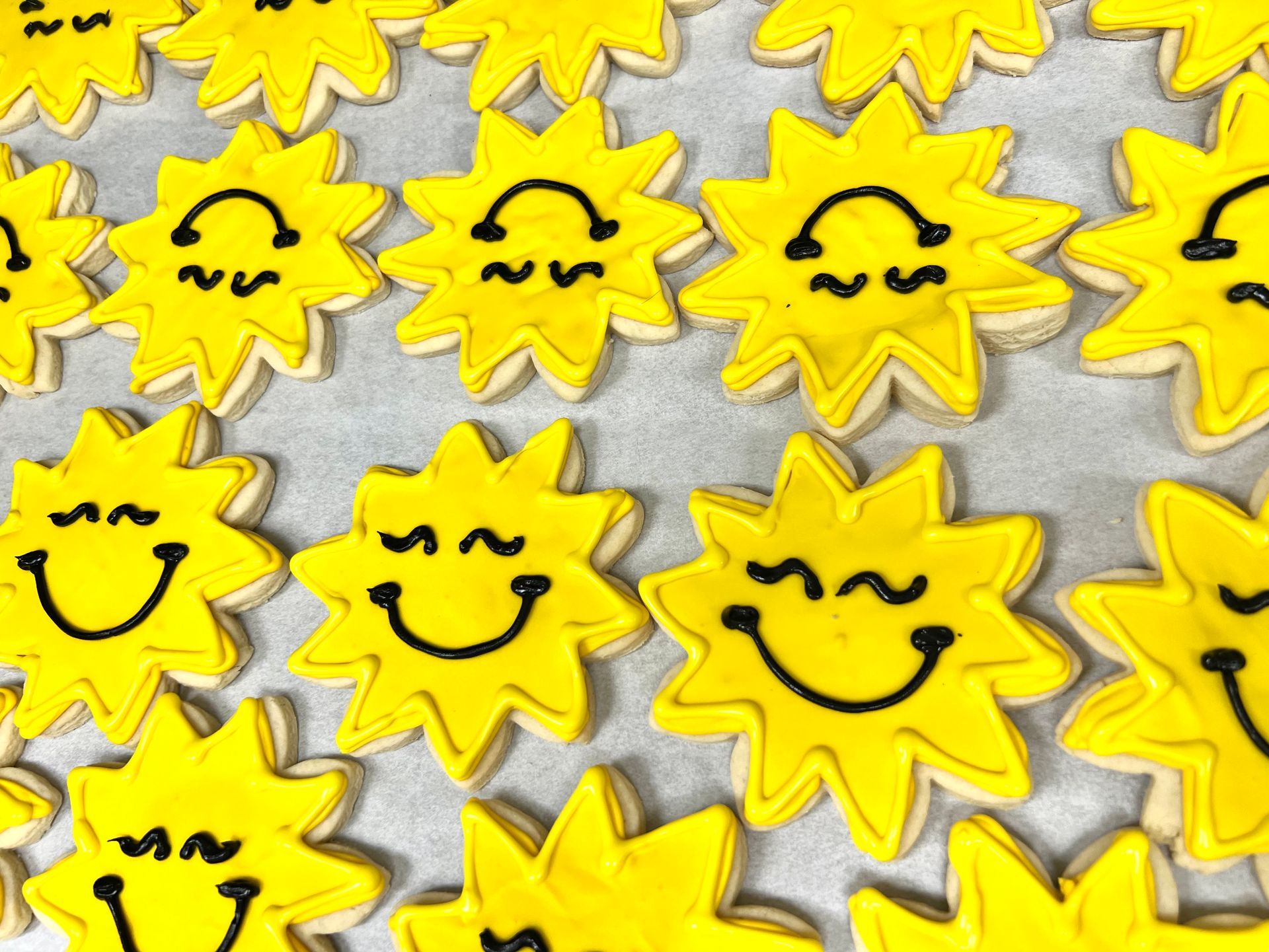 a bunch of yellow cookies with smiley faces on them