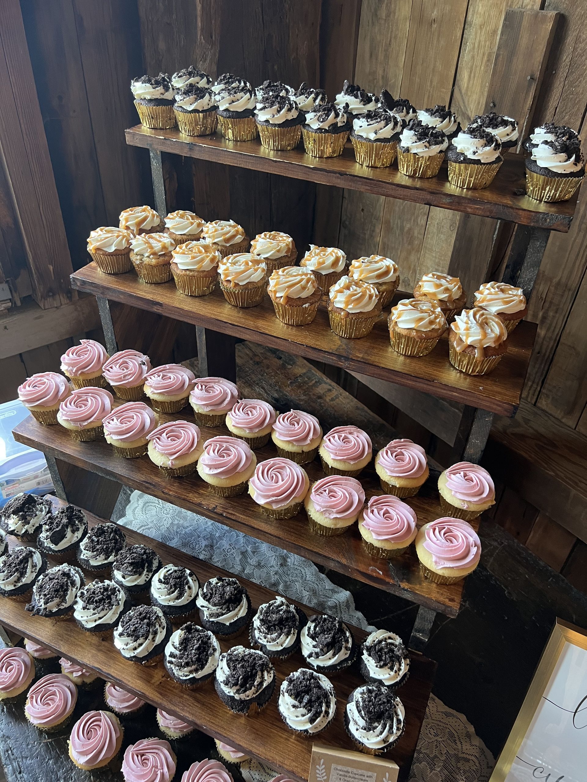 a bunch of cupcakes are sitting on a wooden shelf .