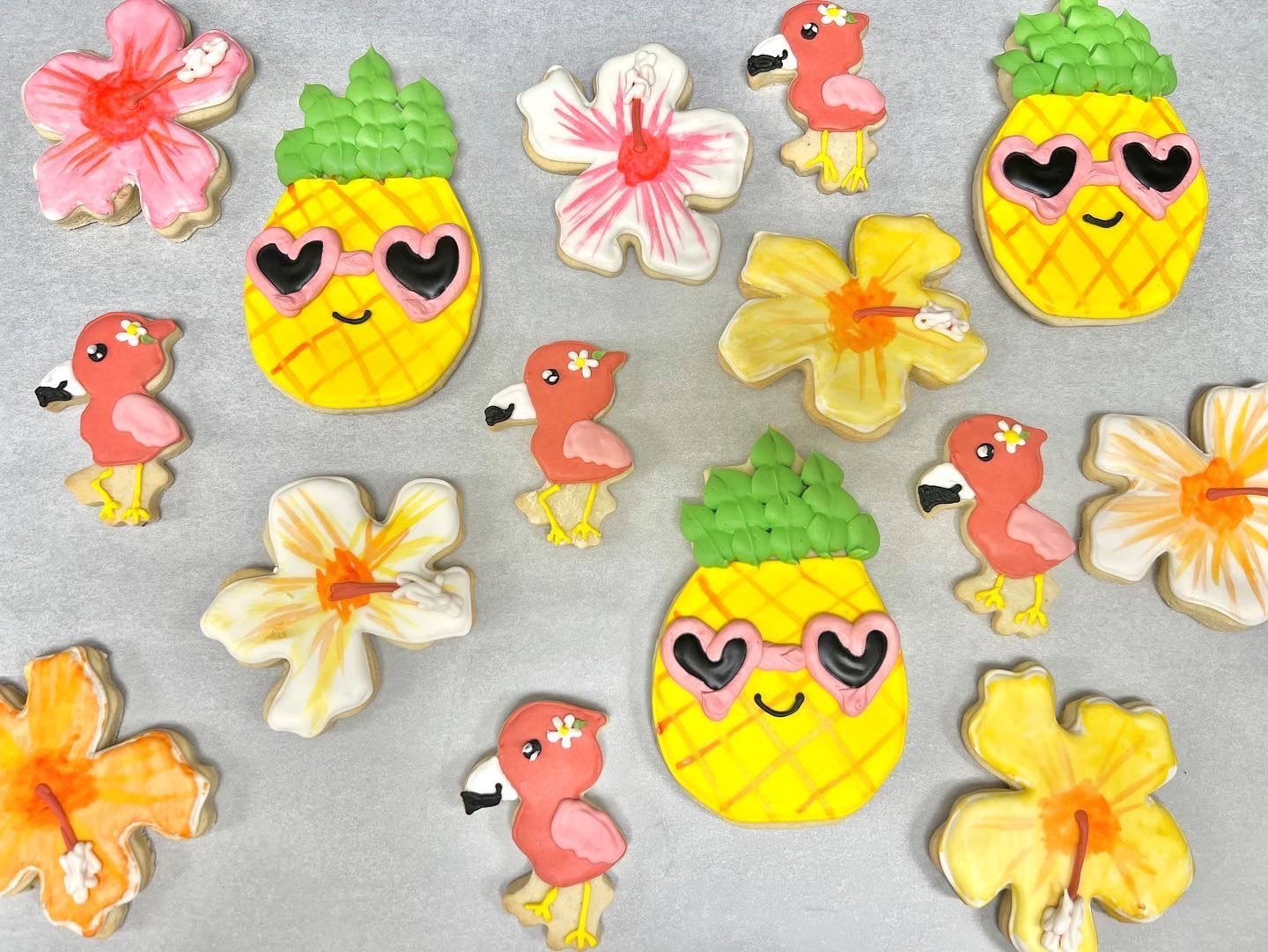 a bunch of cookies with flamingos and pineapples on them