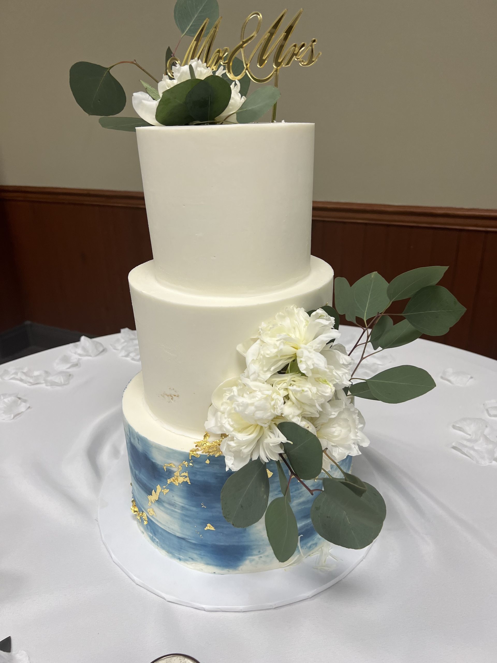 a wedding cake is sitting on top of a white table cloth .