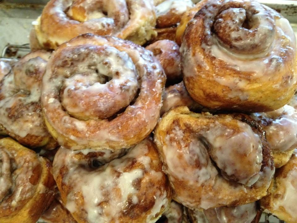 a bunch of cinnamon rolls are sitting on top of each other on a table .