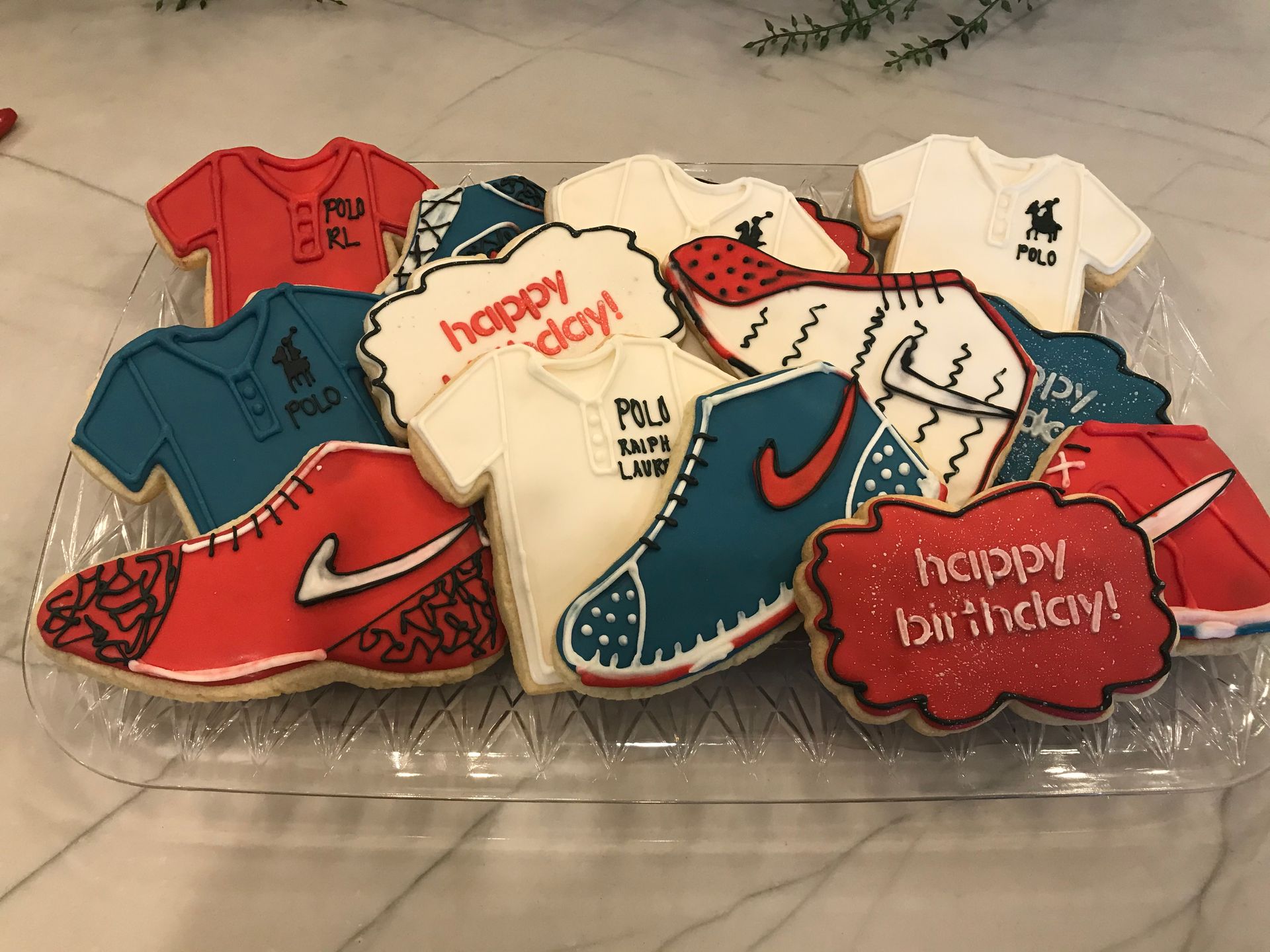 a tray of cookies decorated to look like nike shoes and polo shirts