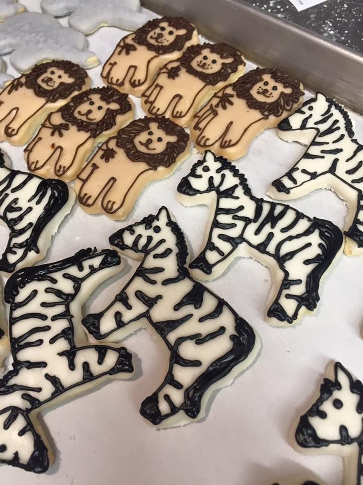 a bunch of cookies in the shape of zebras and lions