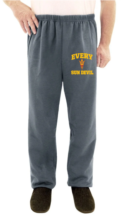 Person wearing dark gray sweatpants with yellow text and black slippers on a white background