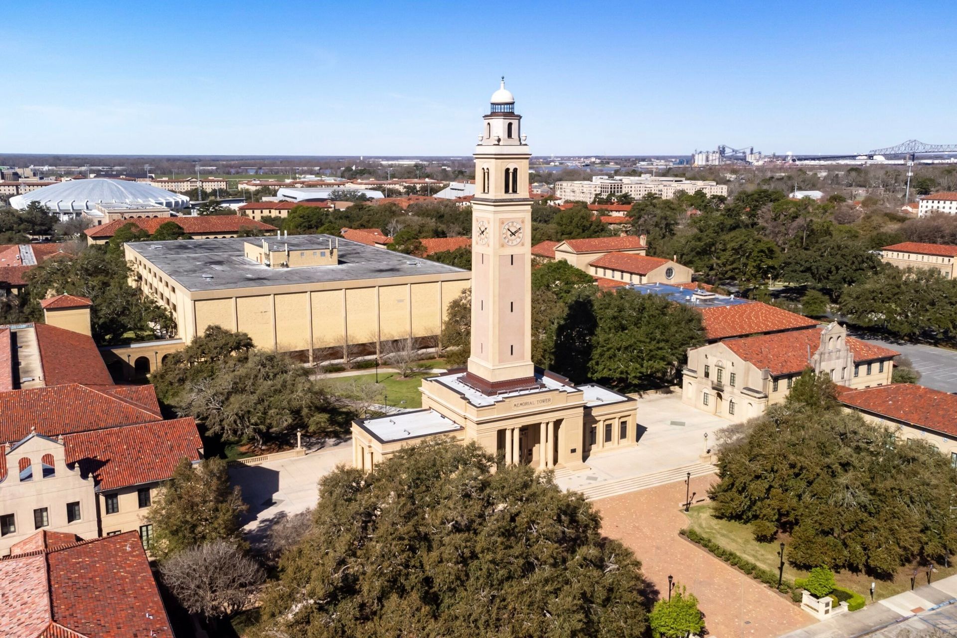 Aerial view of a church tower and red-roofed buildings in a town center
