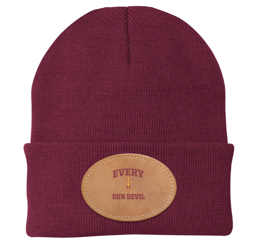 Maroon knit beanie with tan oval patch and embroidered text on the front