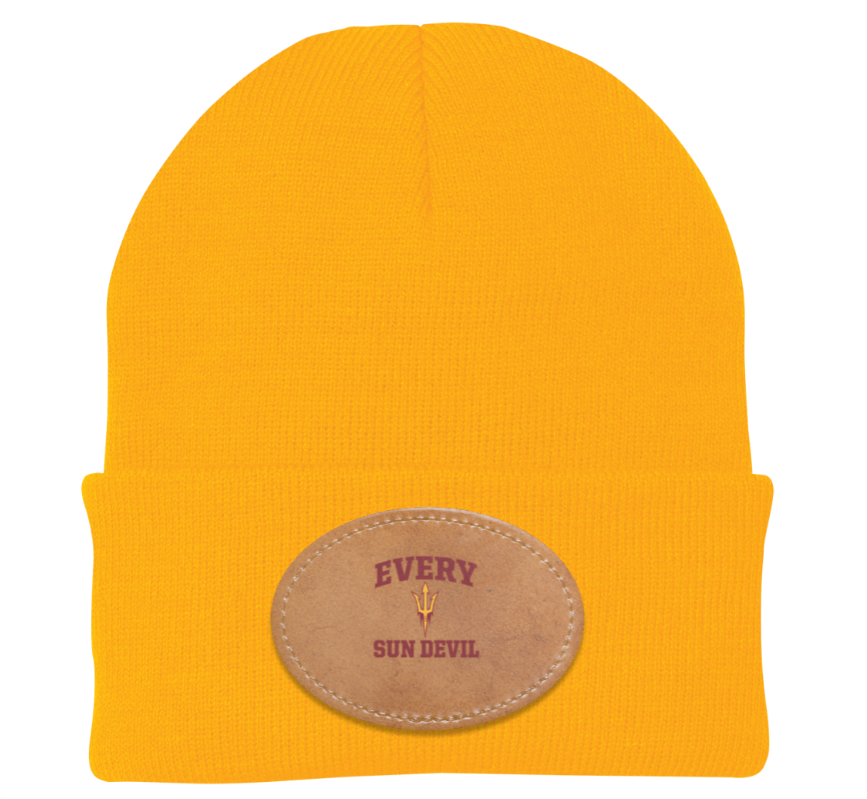Bright yellow beanie with a tan oval leather patch reading “EVERY SKIN DEPIL.”