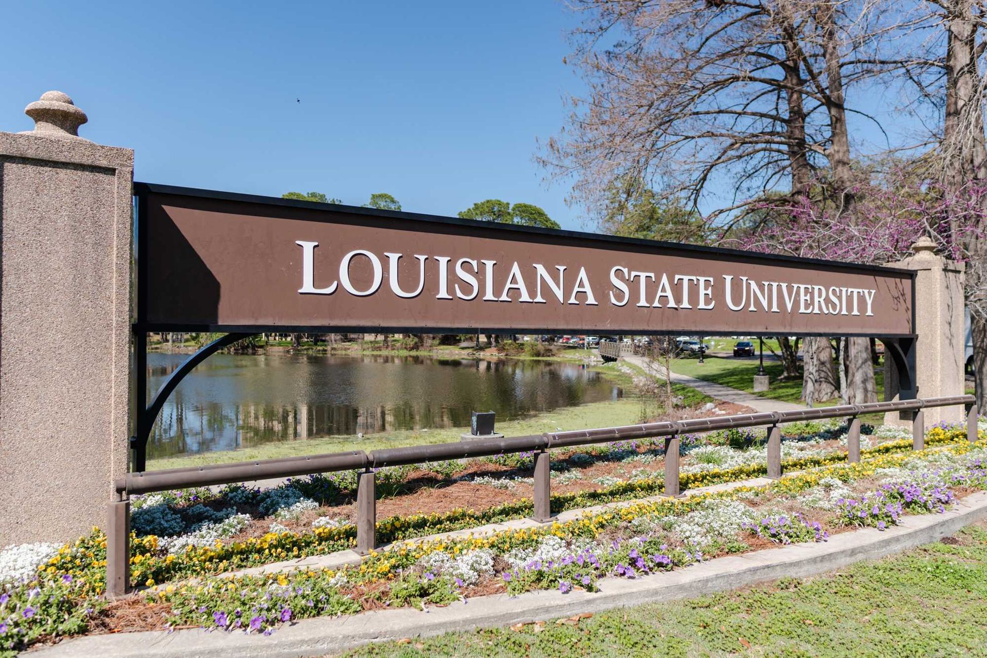Louisiana State University entrance sign with stone pillars and a landscaped walkway