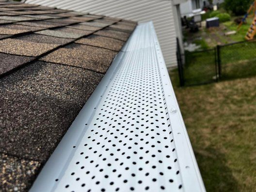 A close up of a gutter on the side of a house.