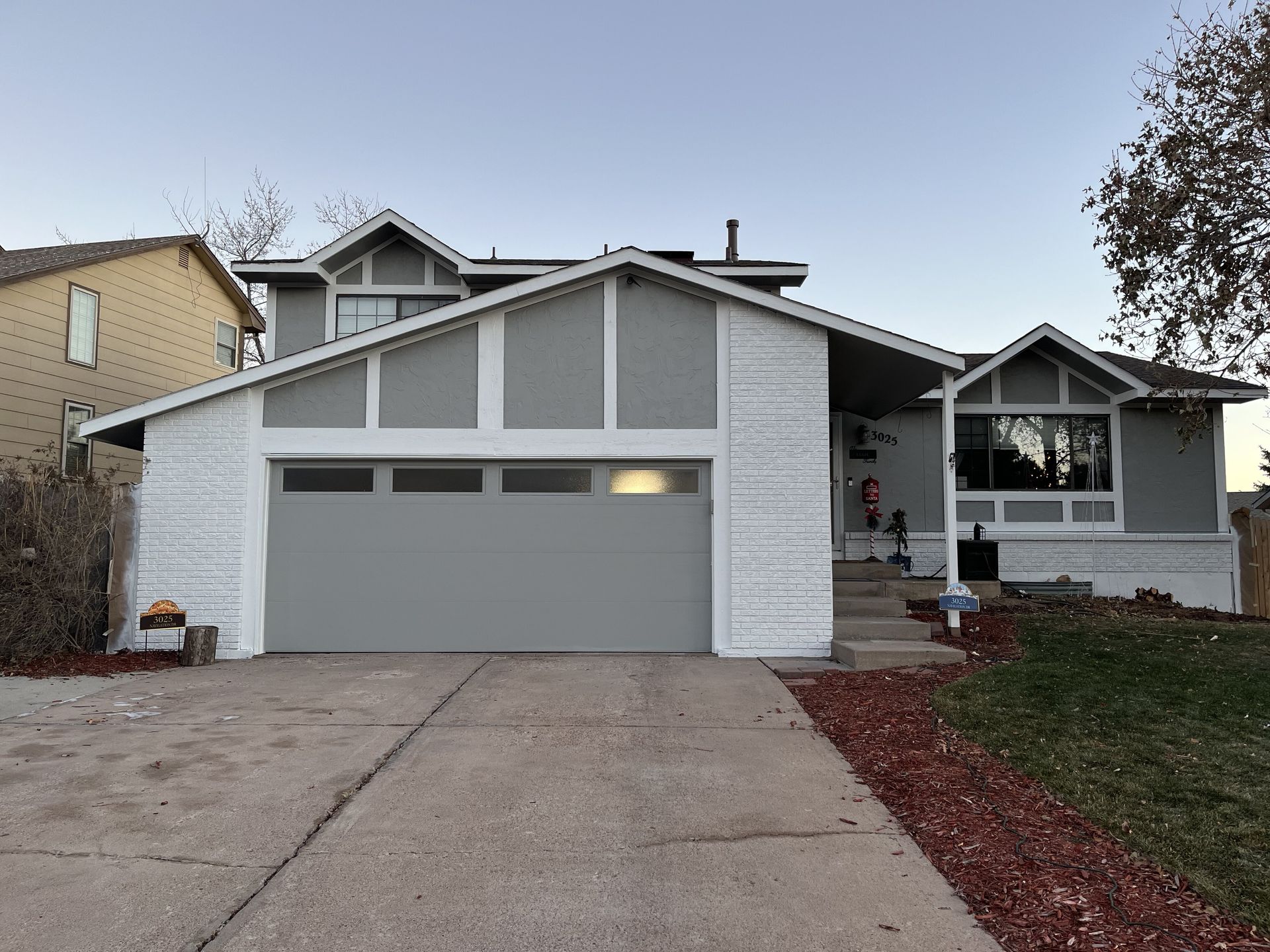A large white house with a gray garage door