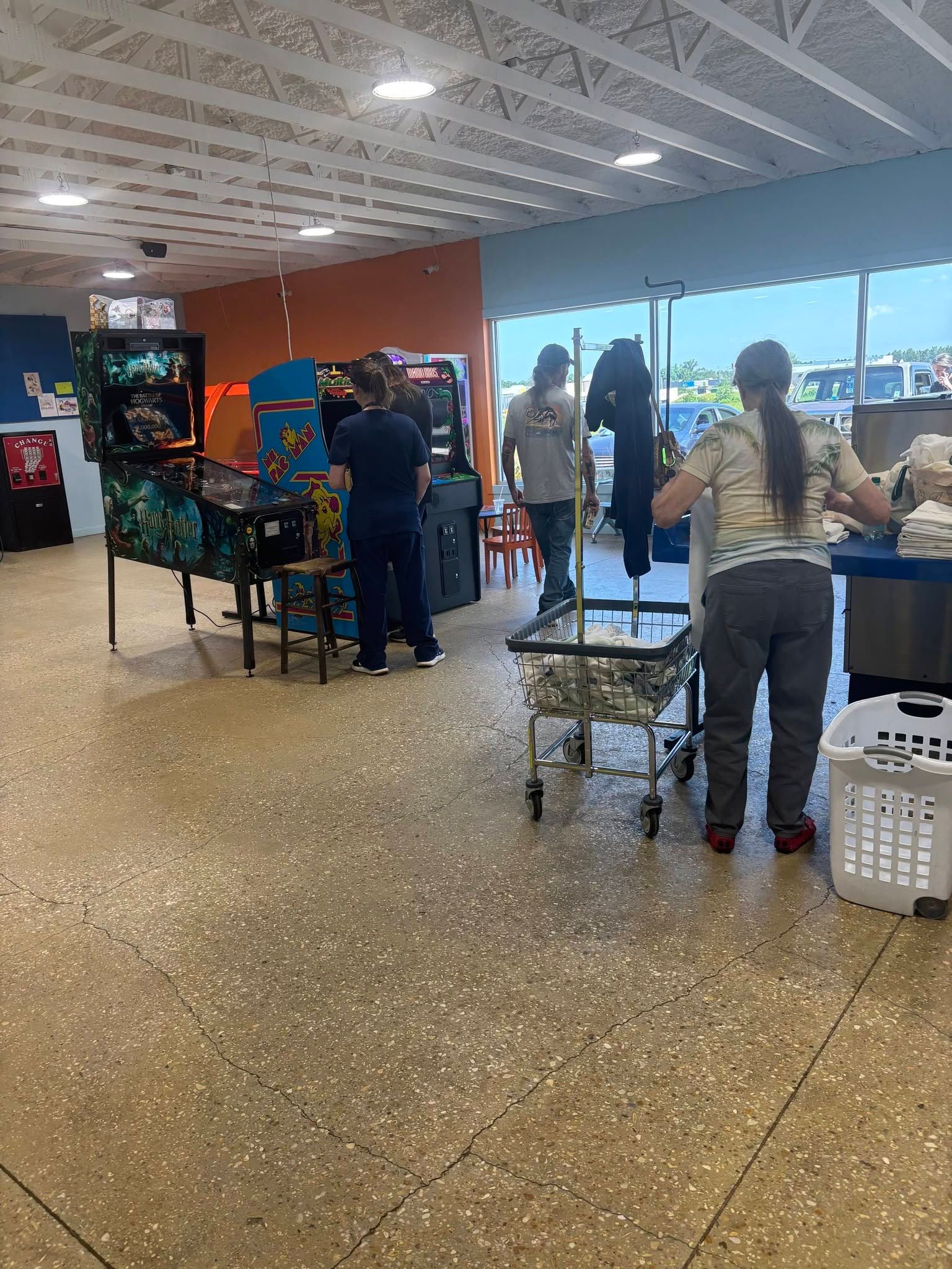 Customers enjoying the arcade area at Sunny Day Laundromat