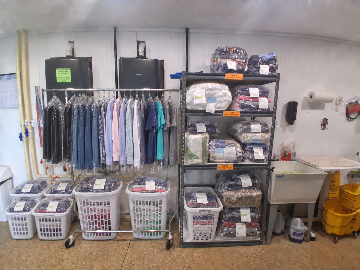 Packaged laundry and hanging garments ready for pickup at Sunny Day