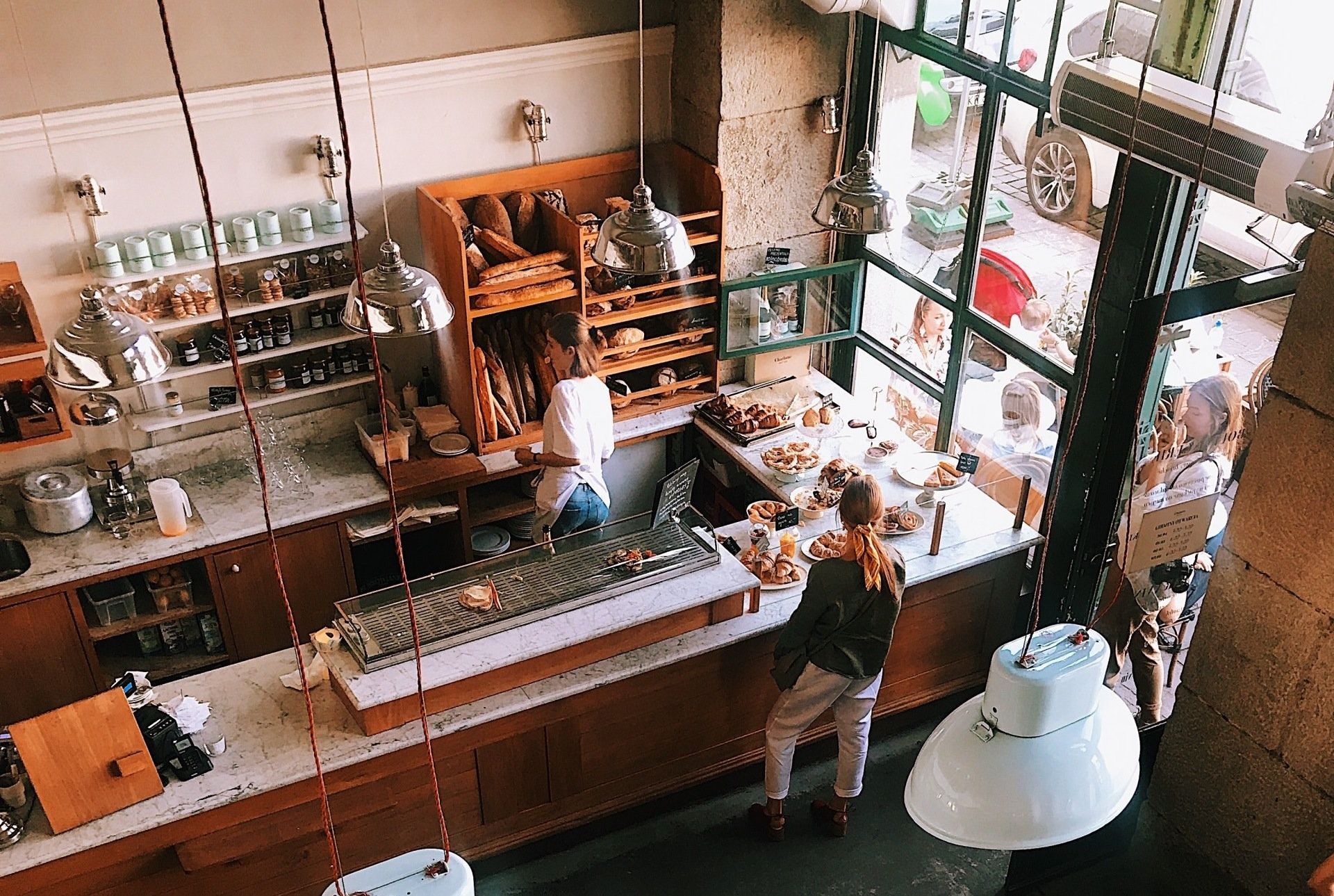 An aerial view of a bakery with a man standing at the counter.