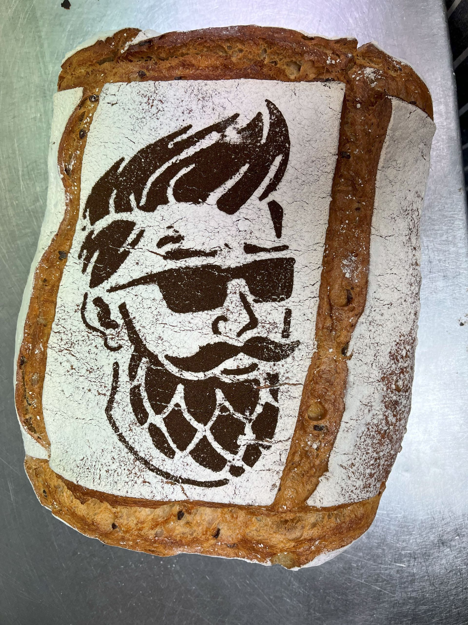 Een brood bedrukt met een sjabloon van een man met een zonnebril en een baard.