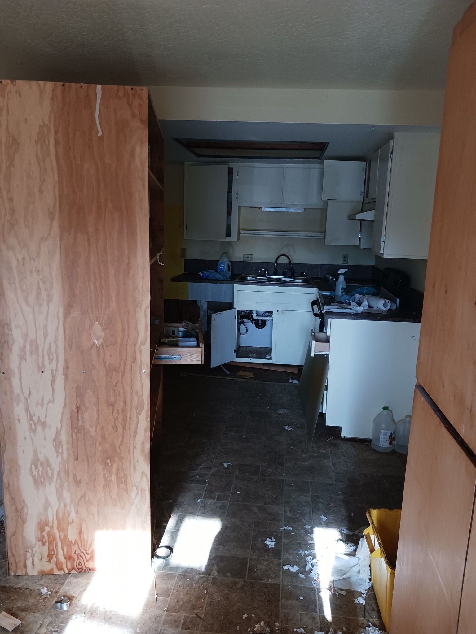 A kitchen with a lot of trash on the floor