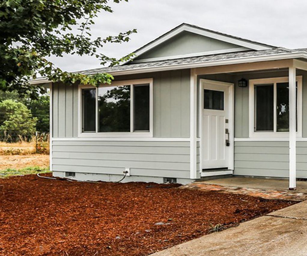 A small house with a porch and a lot of windows