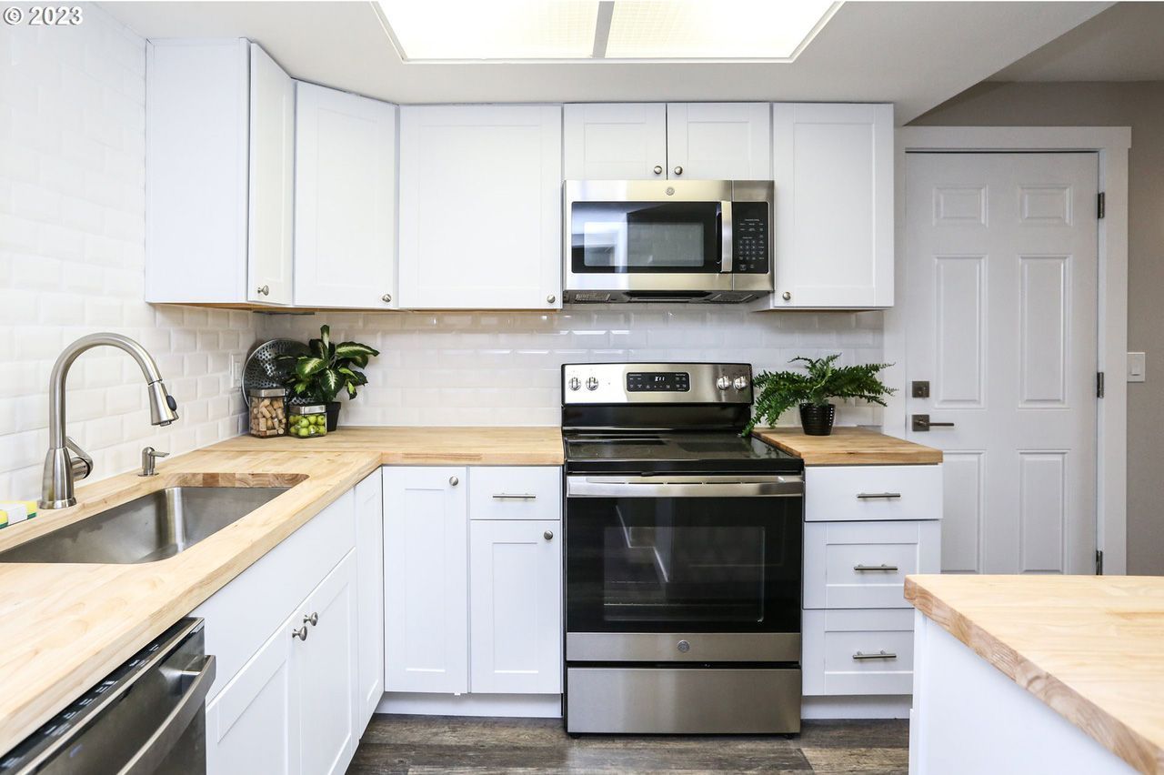 A kitchen with white cabinets and stainless steel appliances