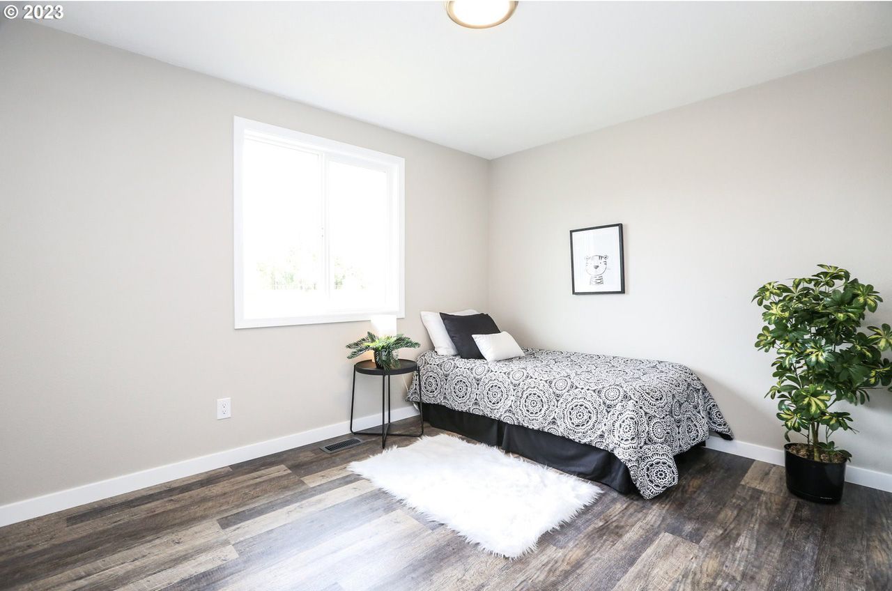 A bedroom with a single bed and a plant