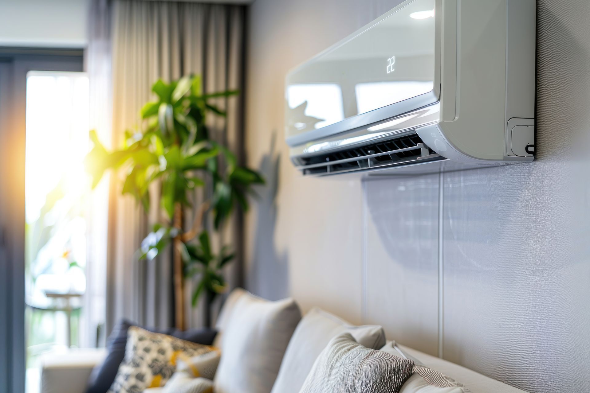 Un salon avec un canapé et un climatiseur au mur.