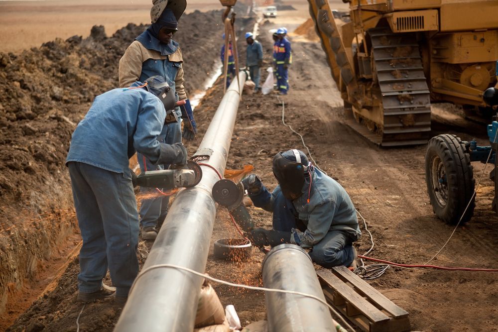A Group Of Men Are Working On A Pipe In The Dirt — Blackpoly Pipelines in Orange, NSW