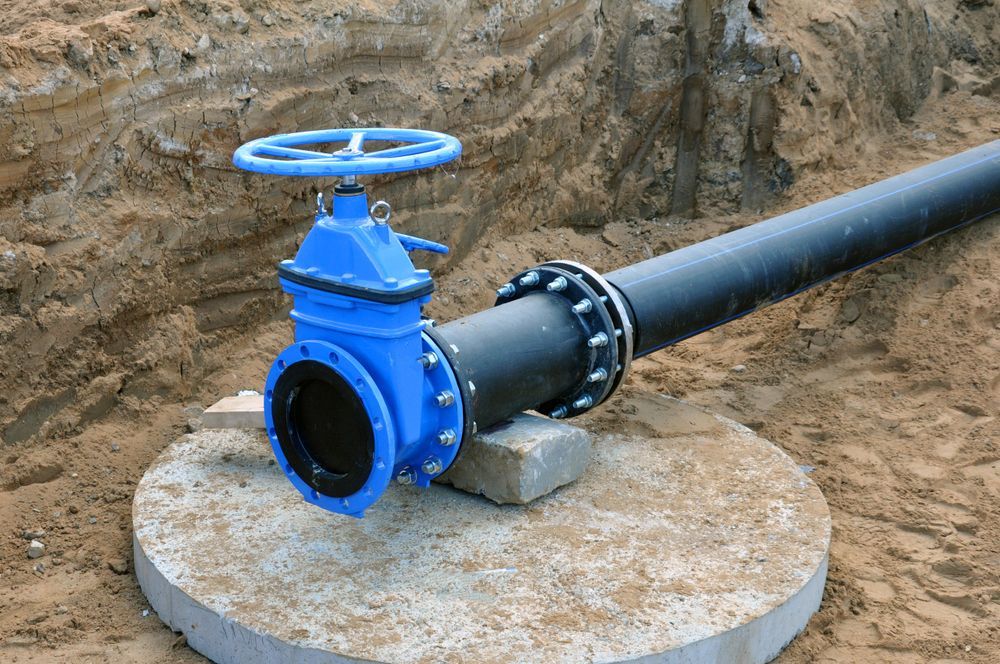 A Blue Valve Is Attached To A Black Pipe In The Dirt — Blackpoly Pipelines in Orange, NSW