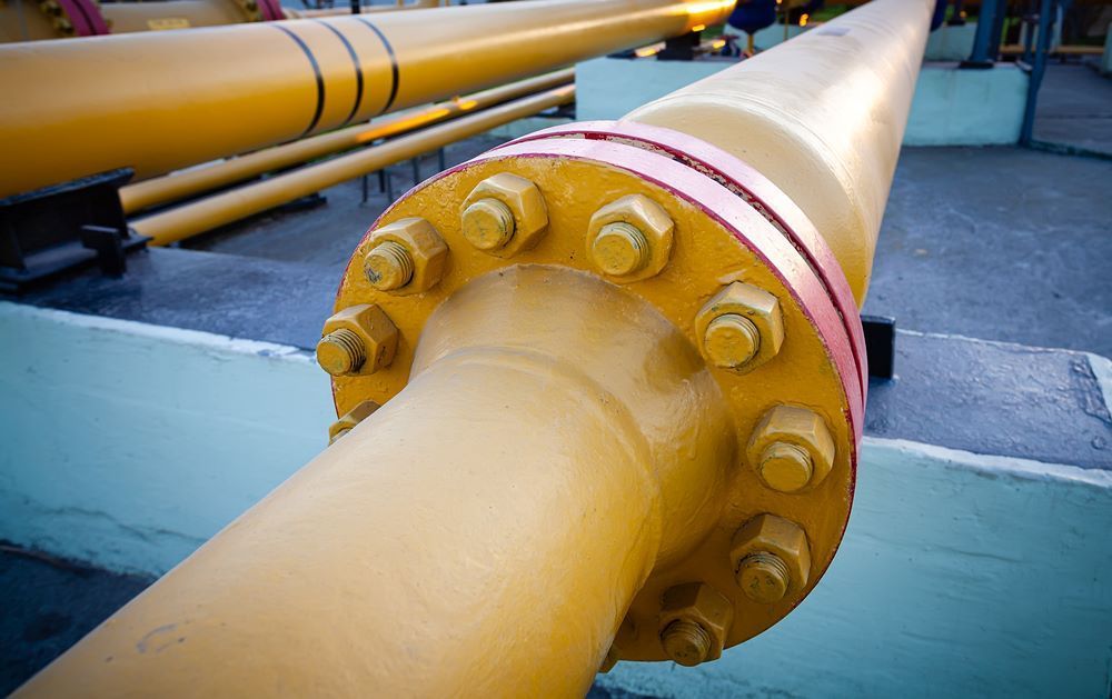 A Close Up Of A Yellow Pipe With Nuts On It — Blackpoly Pipelines in Cowra, NSW