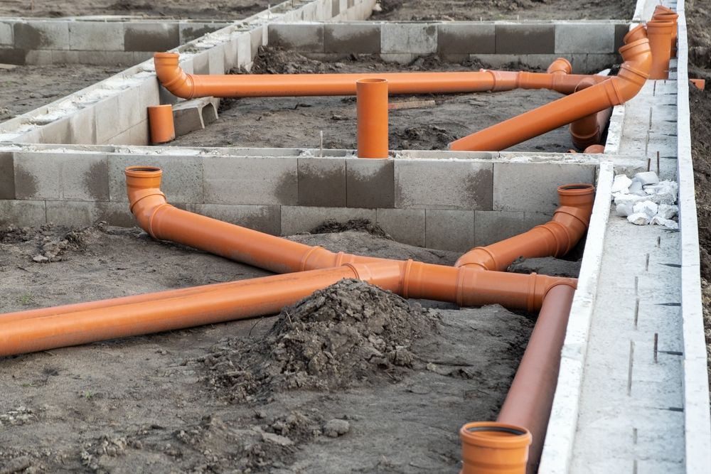 A Bunch Of Orange Pipes Are Laying In The Dirt — Blackpoly Pipelines in Lithgow, NSW