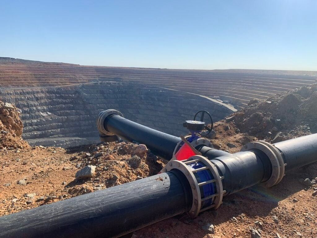 A Large Pipe Is Sitting On Top Of A Dirt Hill — Blackpoly Pipelines in Orange, NSW