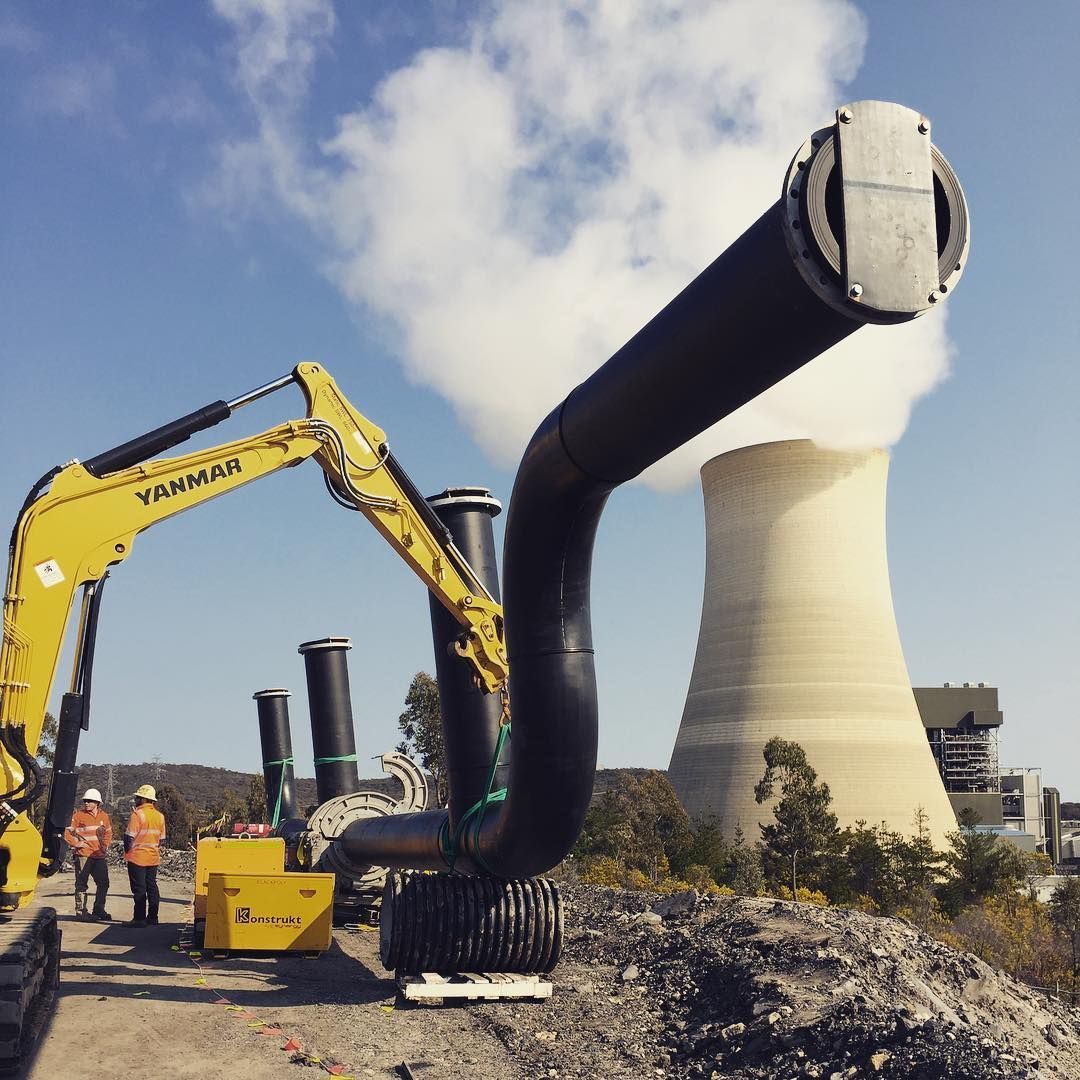 A Yellow Yanmar Excavator Is In Front Of A Cooling Tower — Blackpoly Pipelines in Orange, NSW