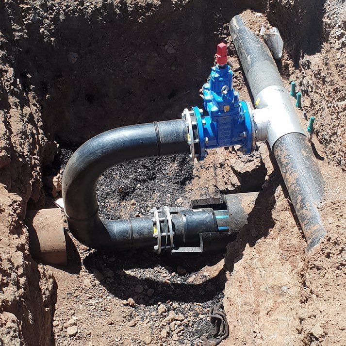 A Blue Valve Is Attached To A Black Pipe In The Dirt — Blackpoly Pipelines in Parkes, NSW