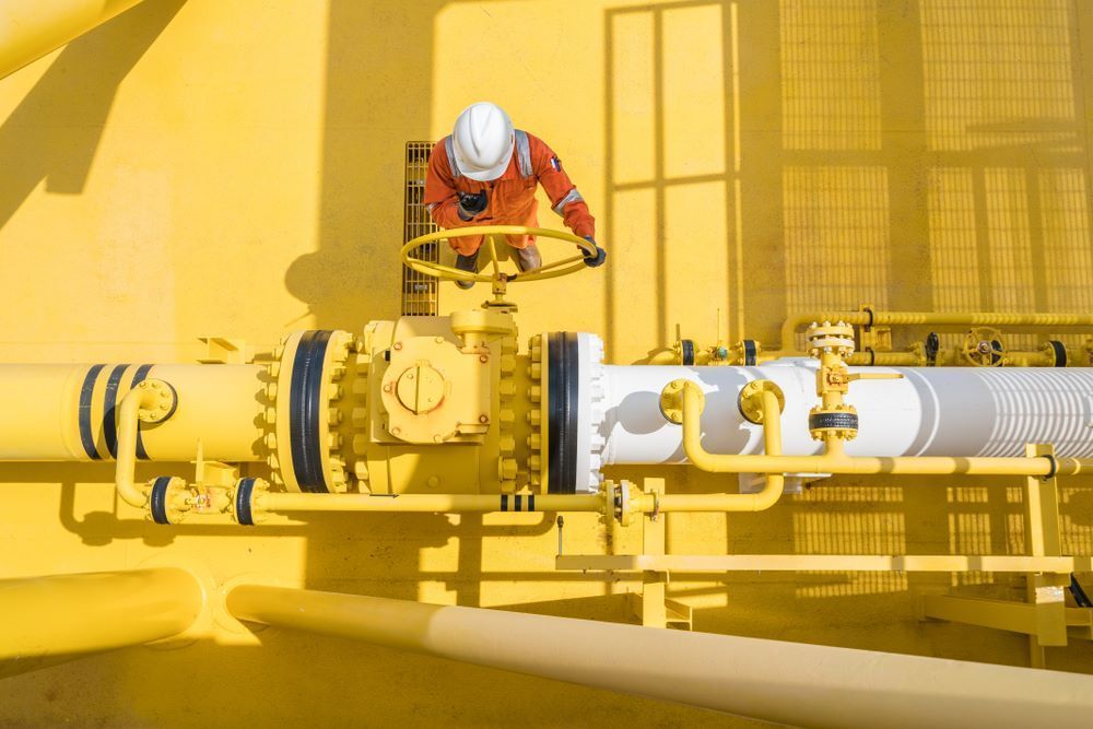 A Man Is Standing On Top Of A Yellow Pipe — Blackpoly Pipelines in Cloncurry, QLD