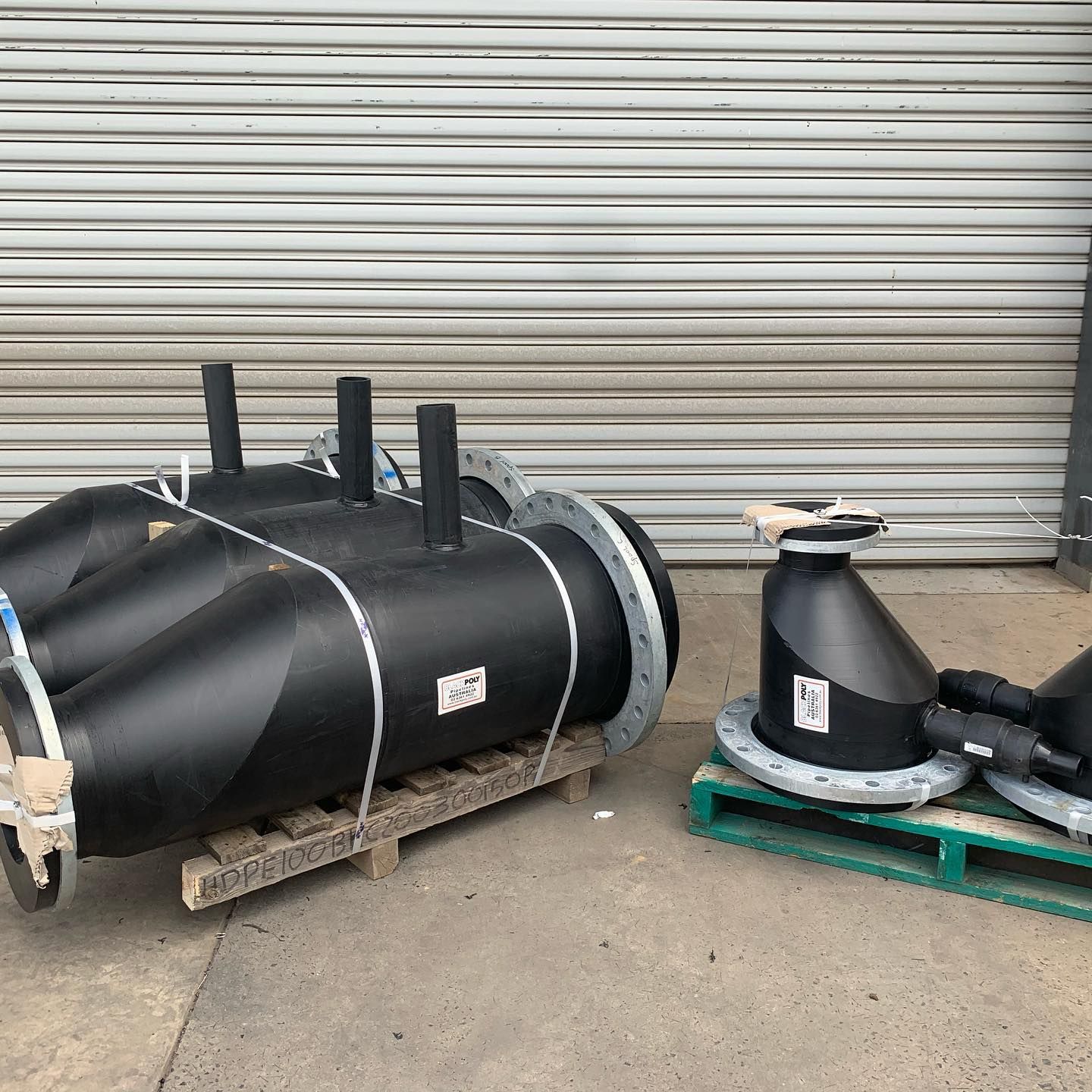 A Bunch Of Black Pipes Are Sitting On A Wooden Pallet — Blackpoly Pipelines in Lithgow, NSW