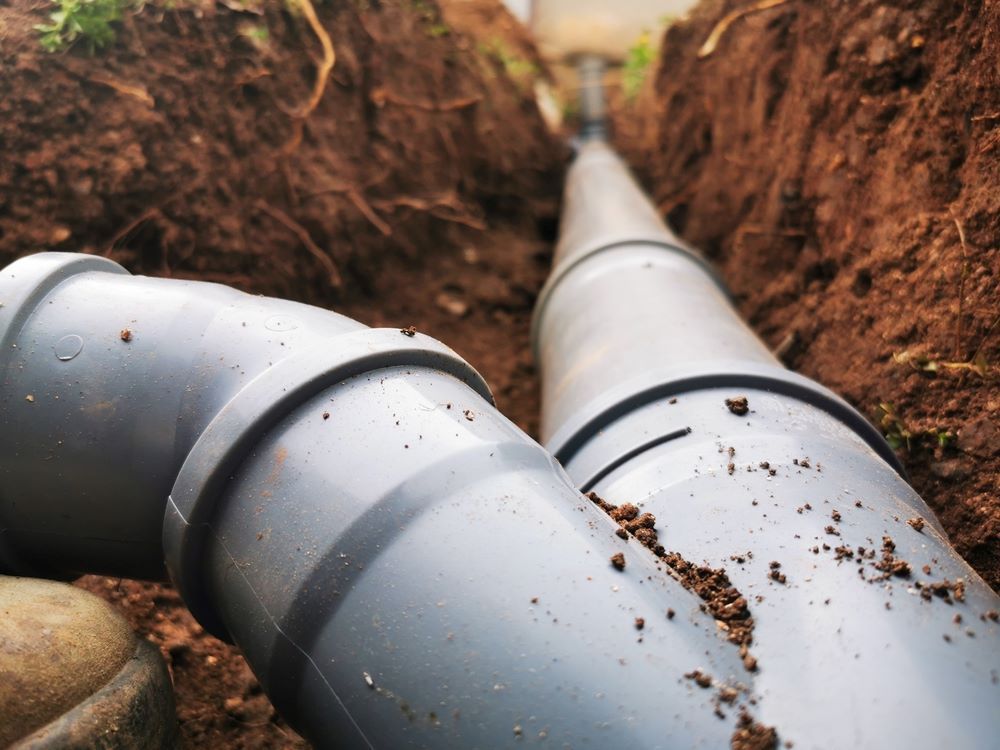 A Couple Of Pipes Are Laying In The Dirt In A Trench — Blackpoly Pipelines in Cowra, NSW